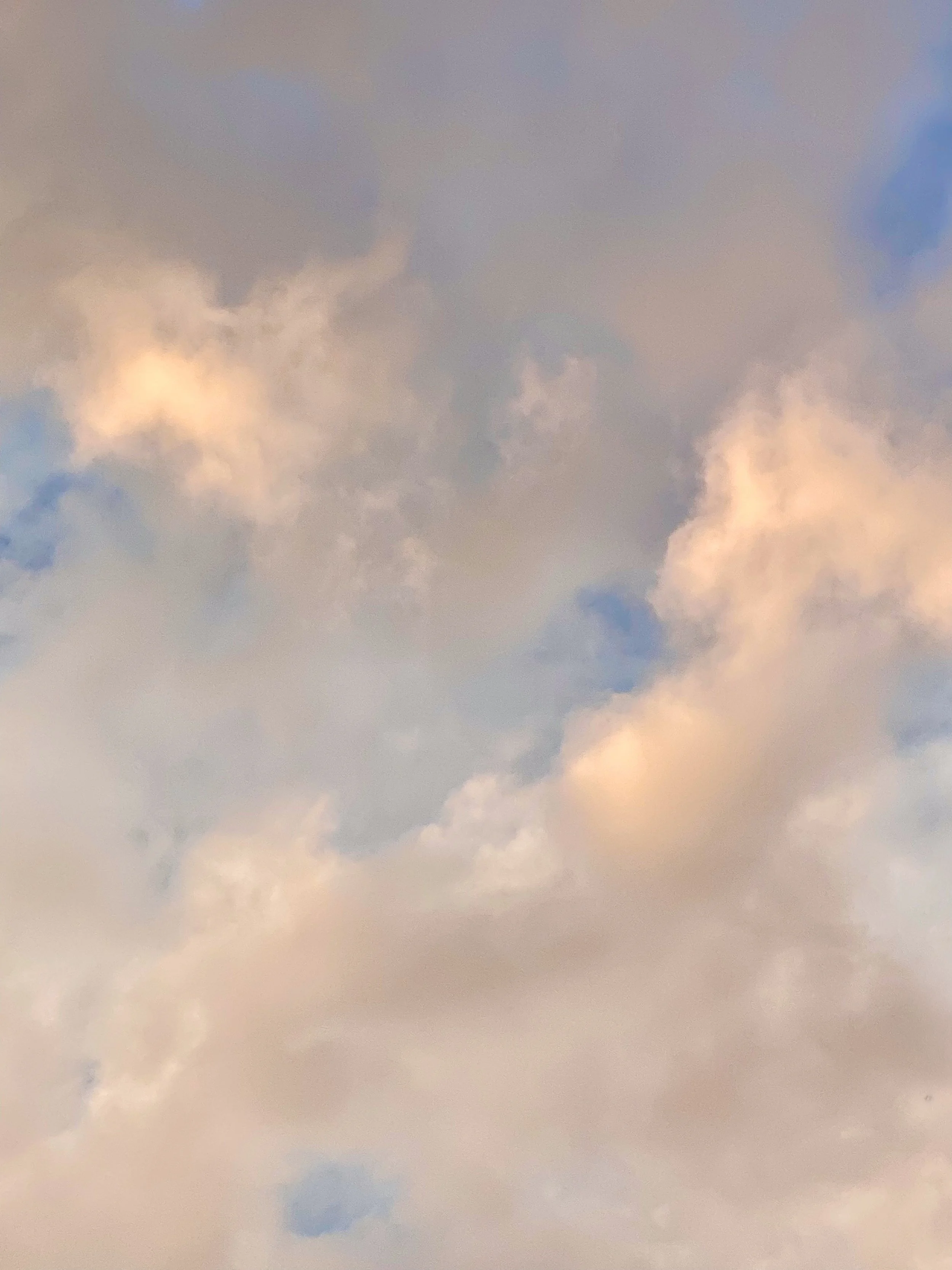 A sky filled with soft, pastel-colored clouds during sunset or sunrise.