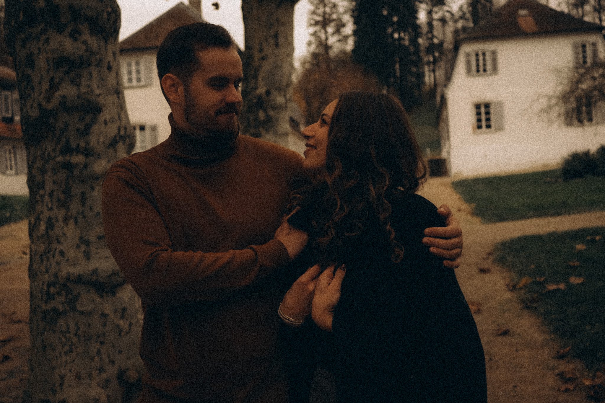 cinematic Paarfotografie Mann zieht frau Jacke an und umarmt sie