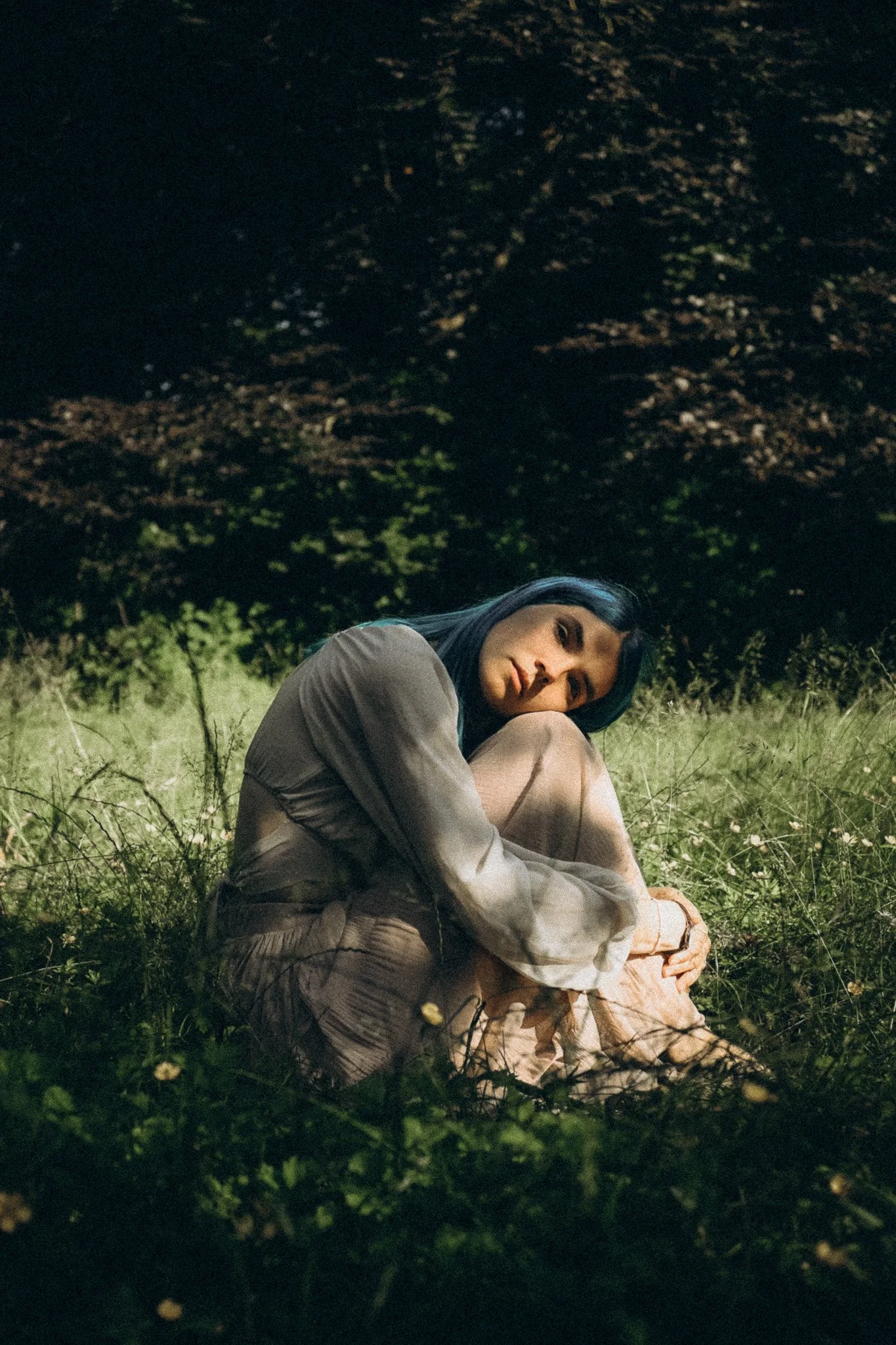 Frau träumerisch im graß sitzend