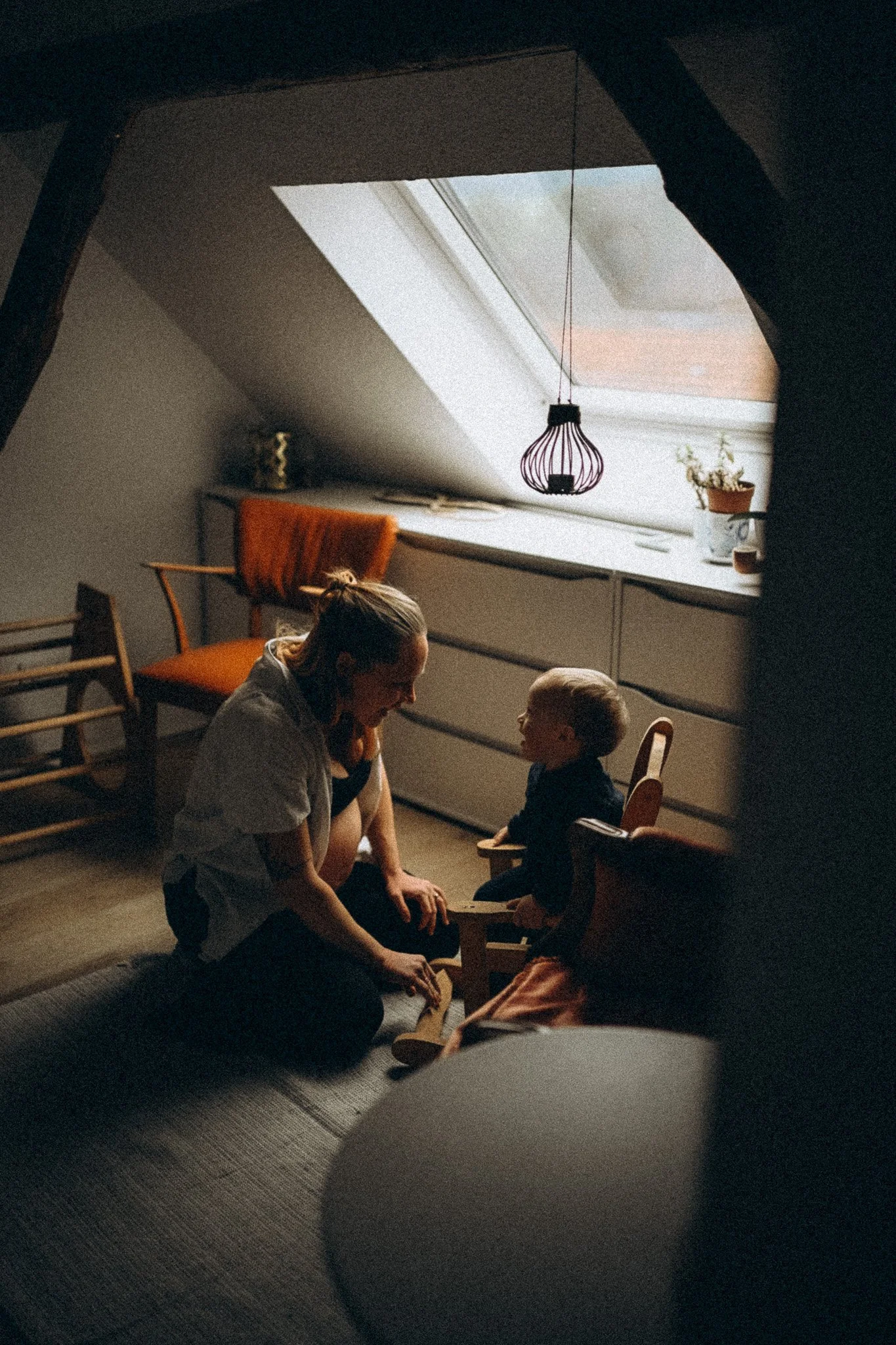 natürliche Familienfotgrafie Schwangere Mama schaukelt Baby im Schaukelstuhl