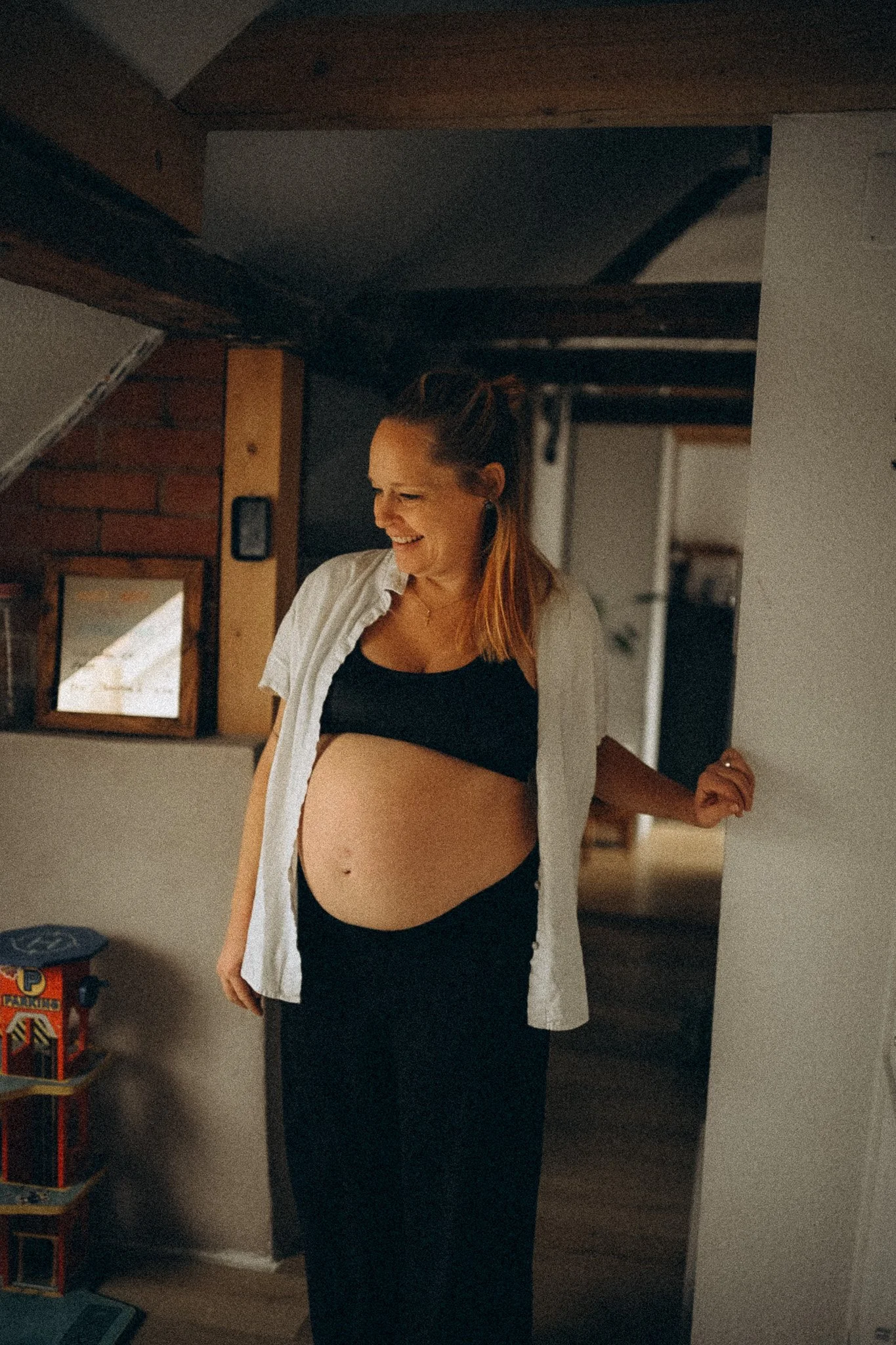 natürliche Familienfotografie in Kassel Schwangere Mama schaut kind beim Spielen zu
