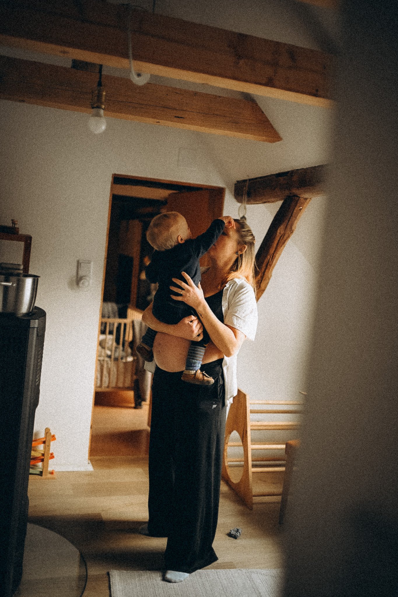 natürliche Familienfotografie in Kassel schwangere Mama spielt mit Baby auf dem Arm