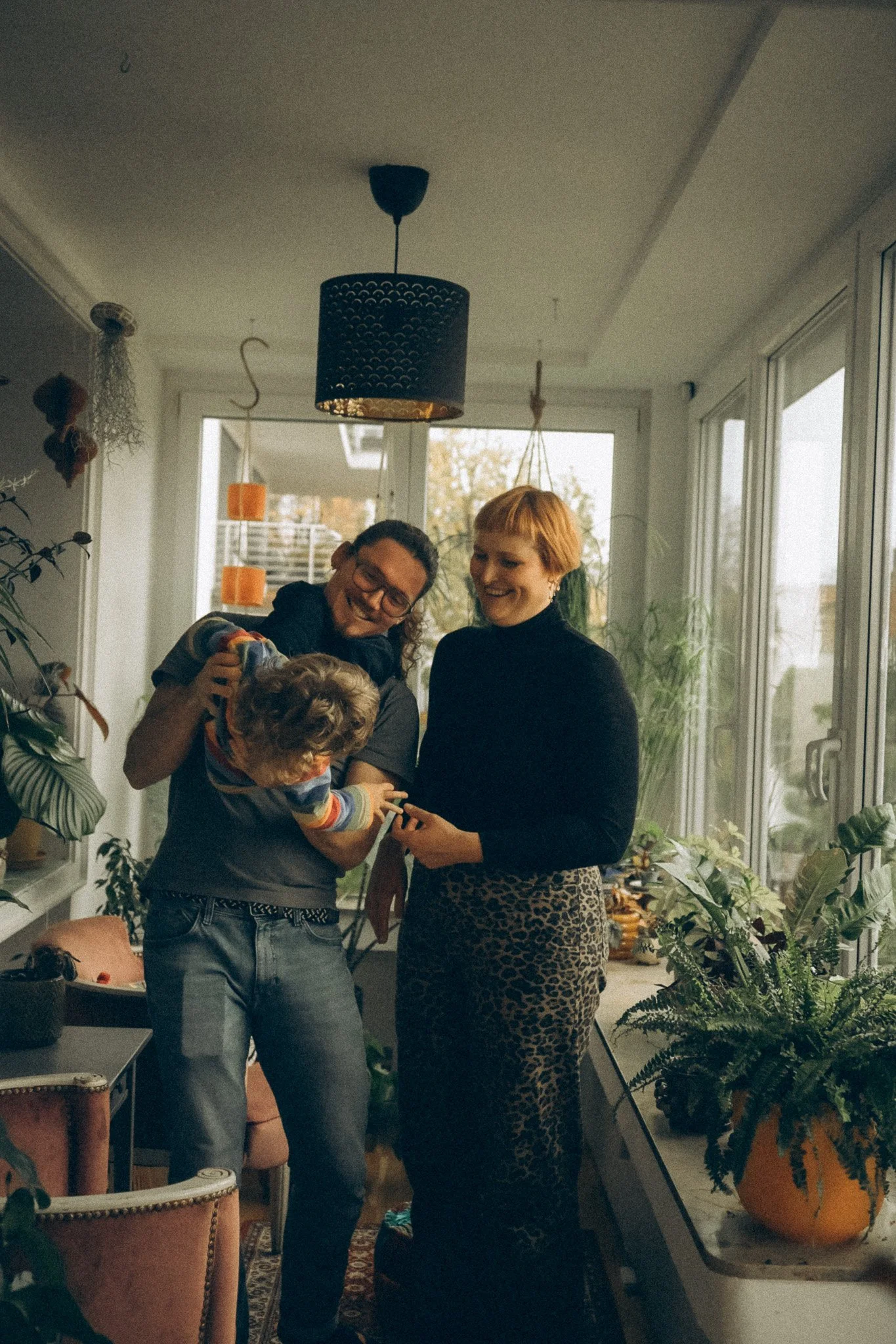 natürtliche Familienfotografie Mama Papa und Kind freuen sich und hampeln rum. Gruppenbild.