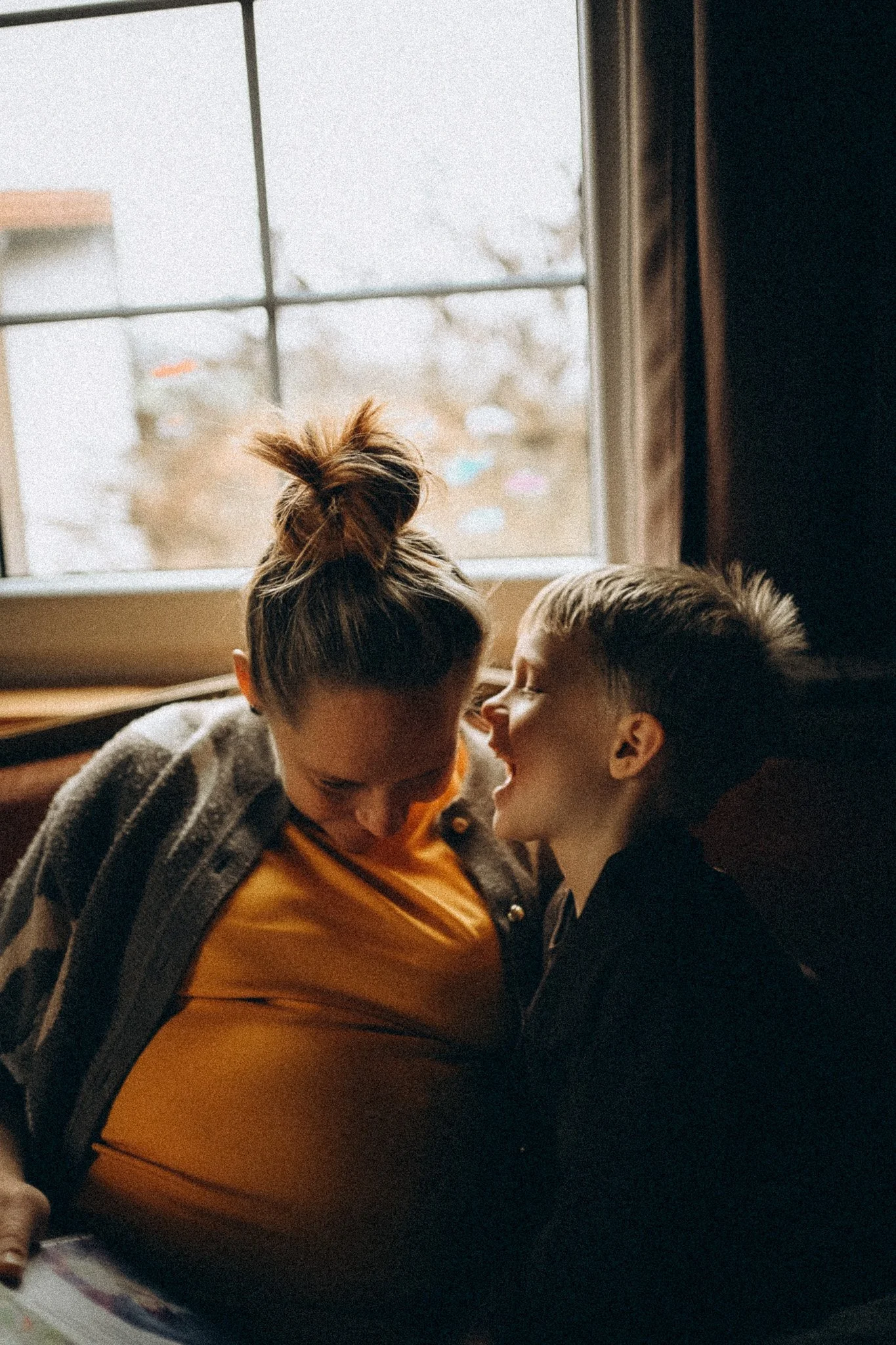 natürtliche Familienfotografie Kind flüstert der Mama etwas ins Ohr