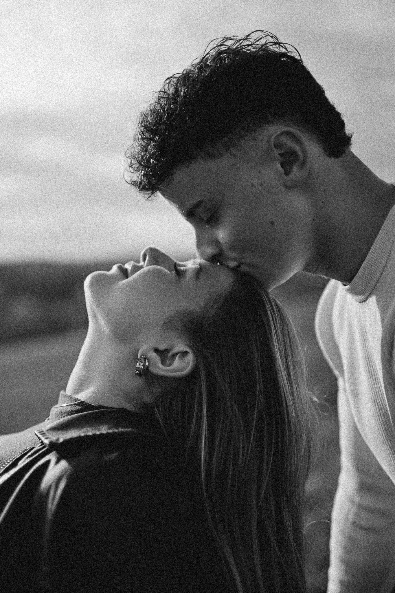 Ein schwar-weiß Foto eines Paares, das sich küsst, wobei der Mann und die Frau nah beieinander stehen und ihre Gesichter sich berühren.