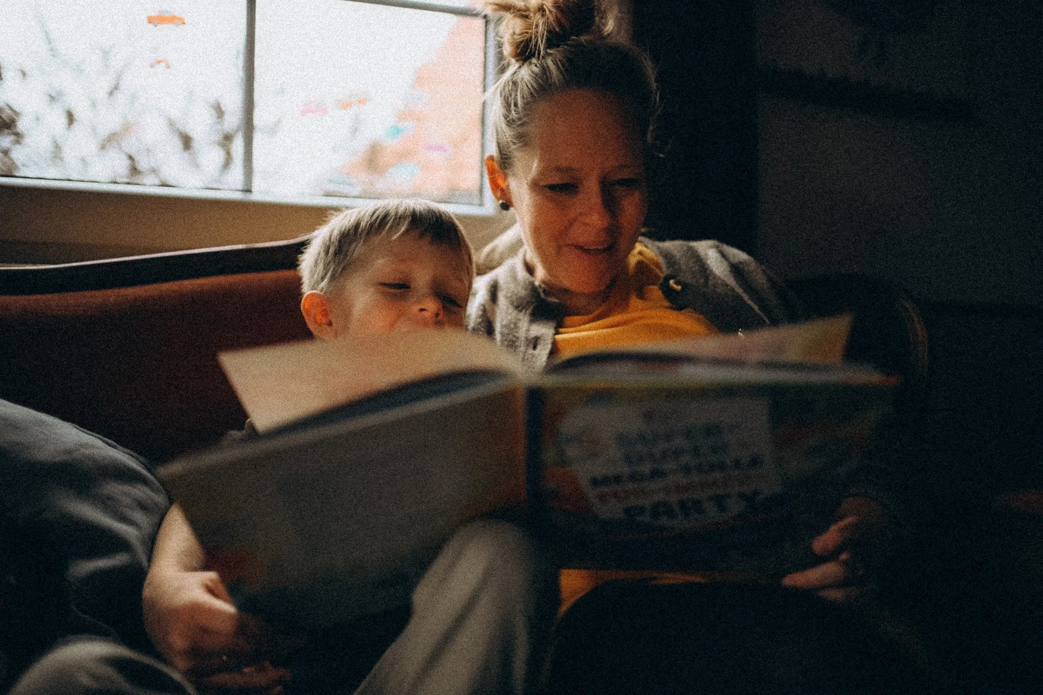 natürliche Familienfotografie in Kassel Mama und Kind freuen sich beim Buch anschauen zuhause