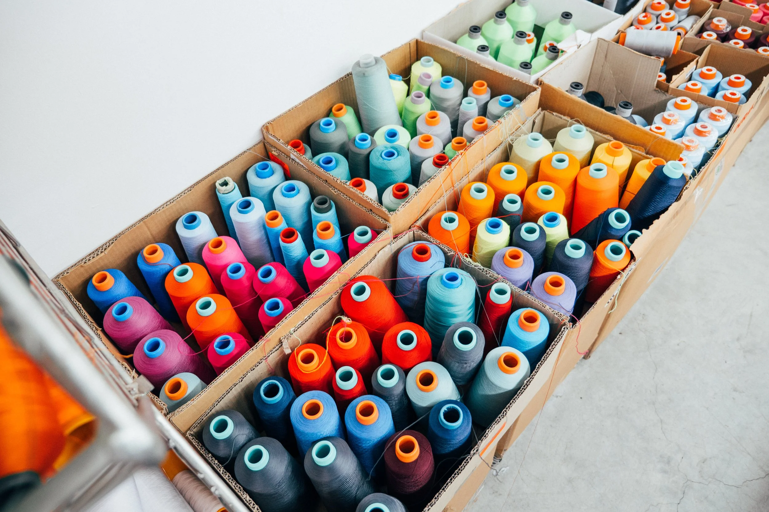 Verschiedene Knäuel bunter Garnrollen in offenen Kartons