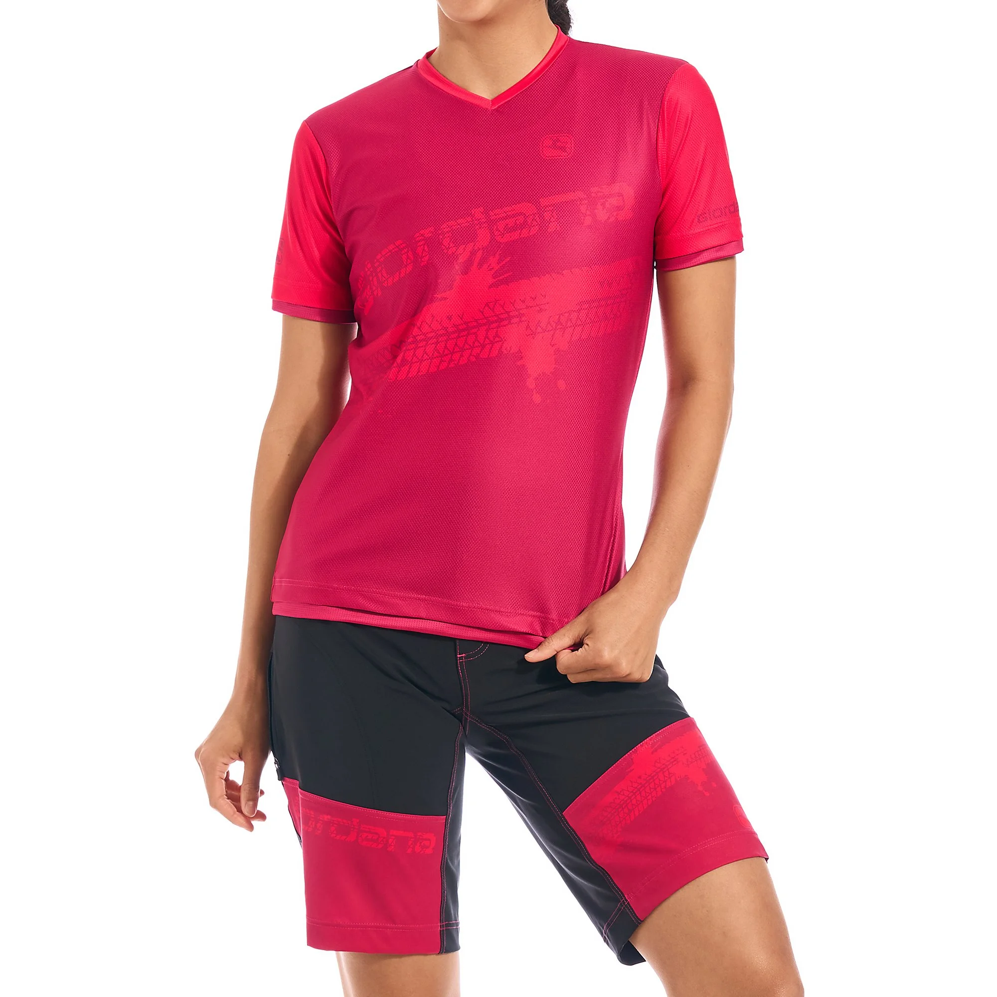 Frau trägt rote und schwarze Sportbekleidung, bestehend aus T-Shirt und Shorts, bei einem Sport- oder Outdoor-Aktivitäts-Setting.