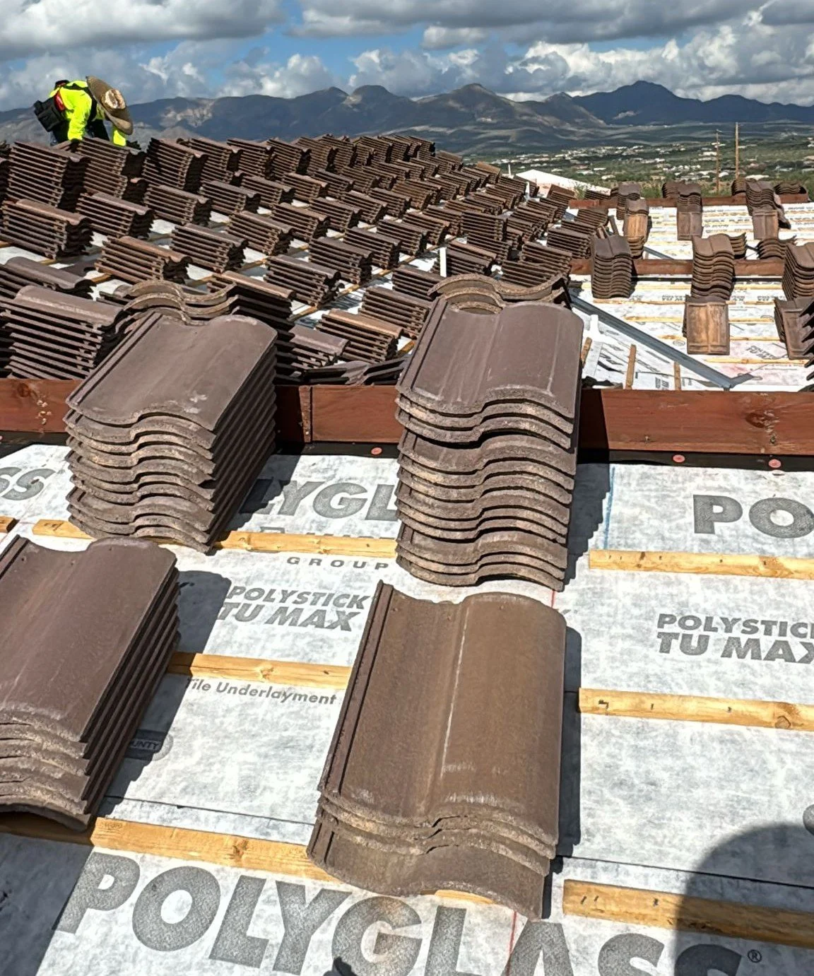 Workers installing concrete s-tile roof tiles on a new construction build in the foothills of Tucson,AZ.