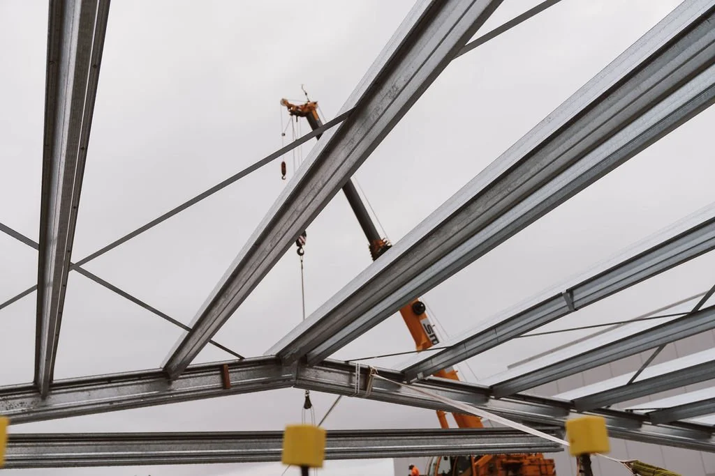 Construction site with metal beams and a crane overhead