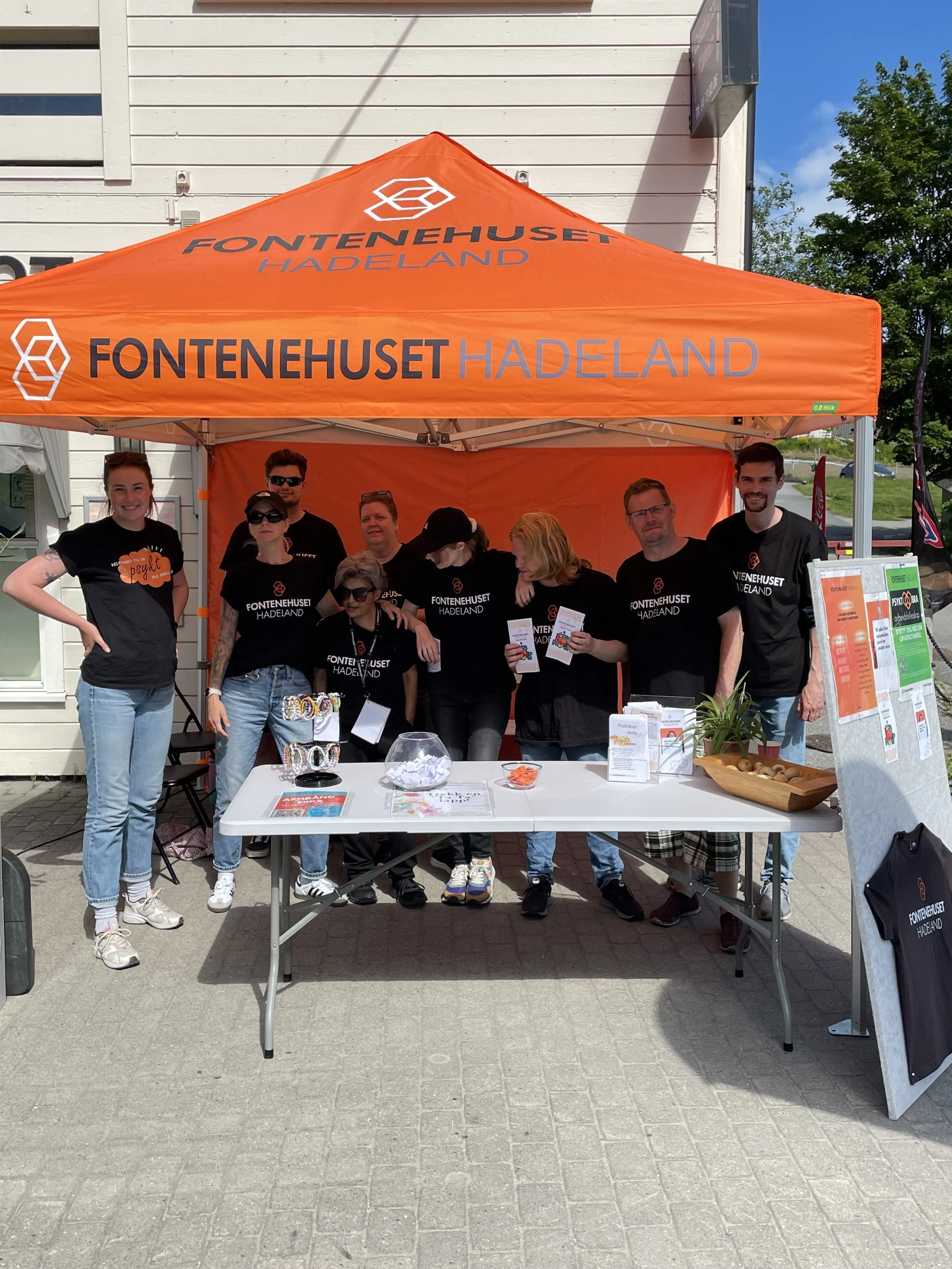 En gruppe mennesker står under en oransje stand med teksten 'FONTENEHUSET HADLAND'.