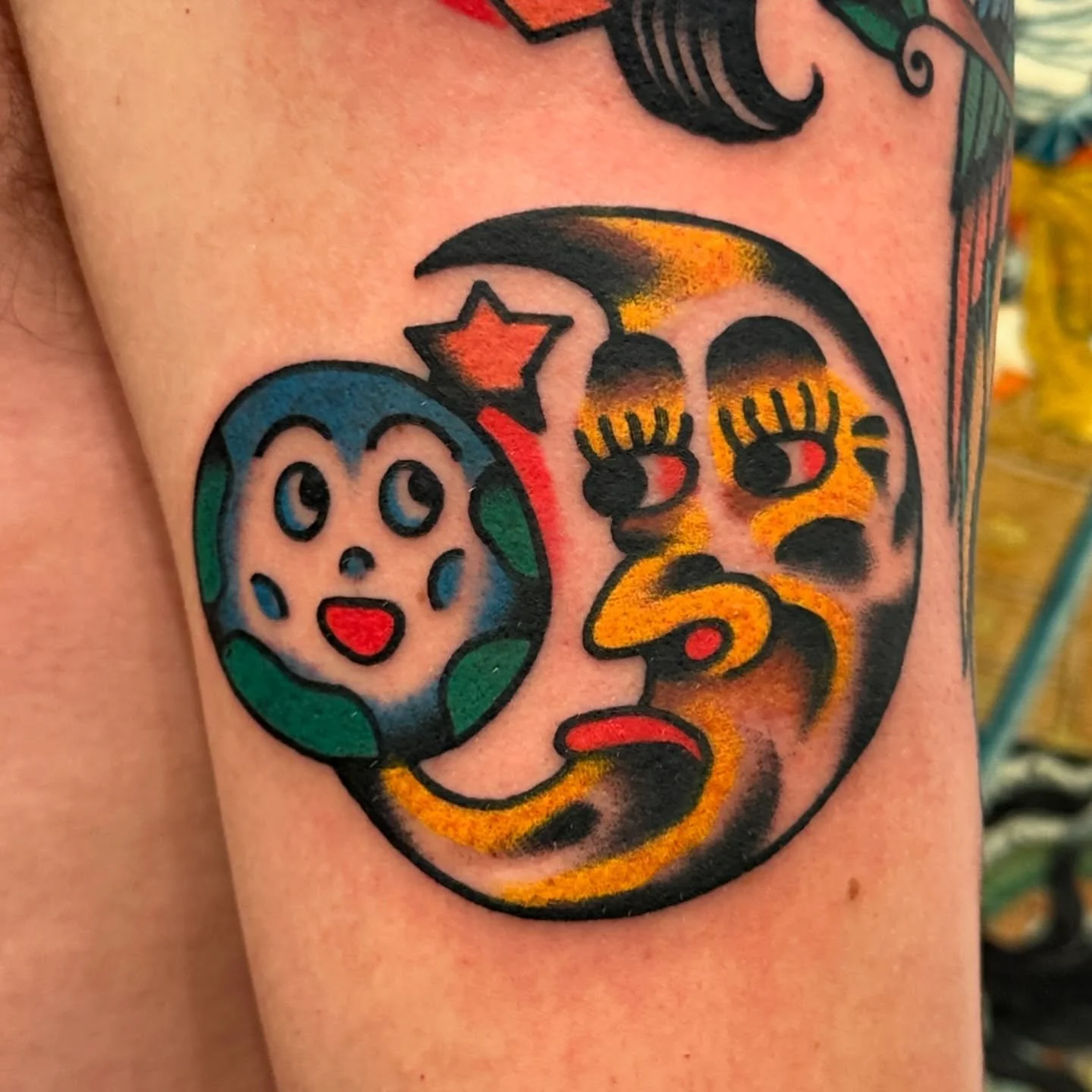 Colorful tattoo of a clown face and a smiling skull with a star and crescent moon, featuring bold black outlines and vibrant colors.