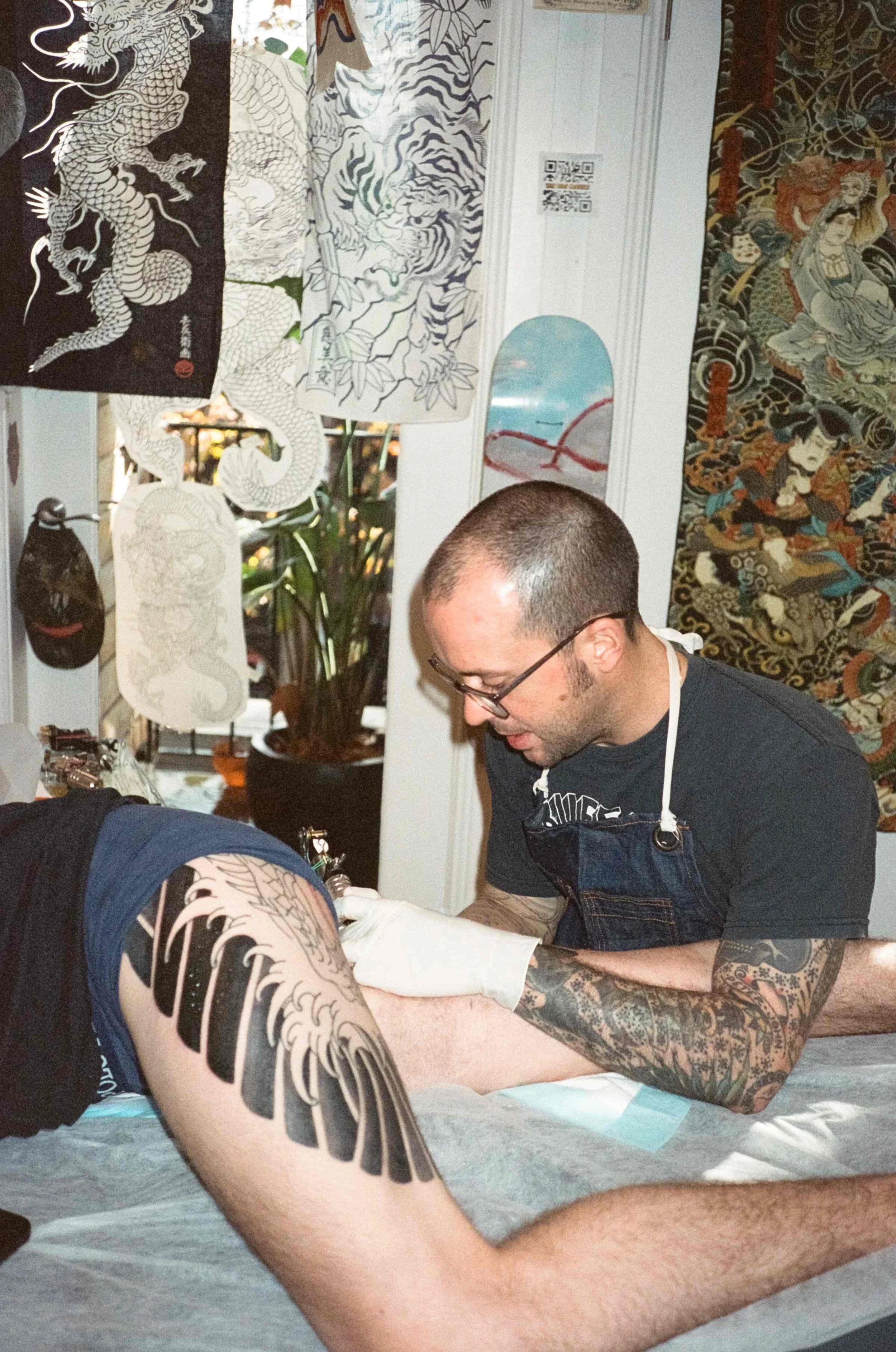 William Brown tattooing client at Tattoo Rosie's