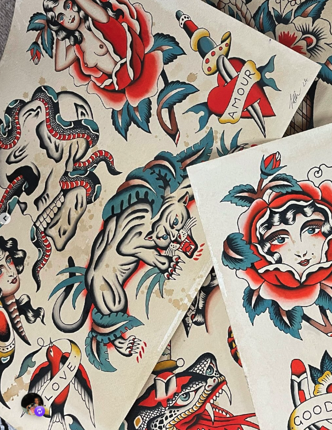 Collection of traditional-style tattoo flash art featuring a woman behind a rose, a snake, a lion, a skull, a snake wrapped around a heart labeled 'Amour', a woman with a rose in her hair, a snake, and other classic tattoo motifs.