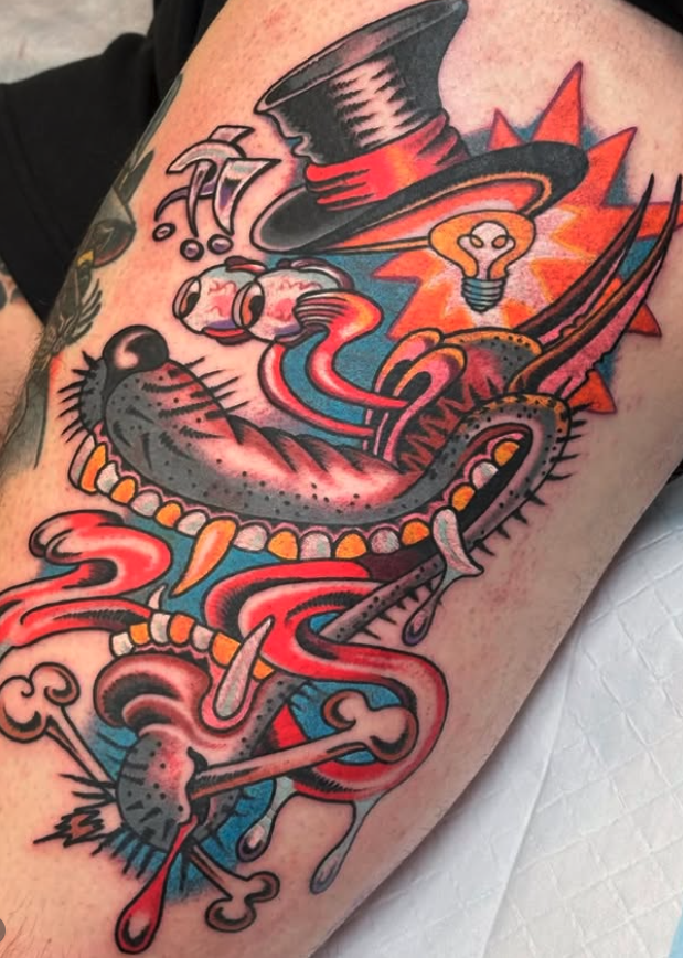 Colorful tattoo of a snake intertwined with a roadrunner, wearing a top hat, with a light bulb and question marks in the background.