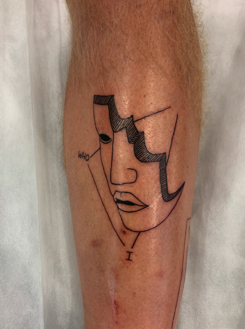 A tattoo of a minimalistic line drawing of a woman's face on a person's leg, with the word 'WHO' written to the side.