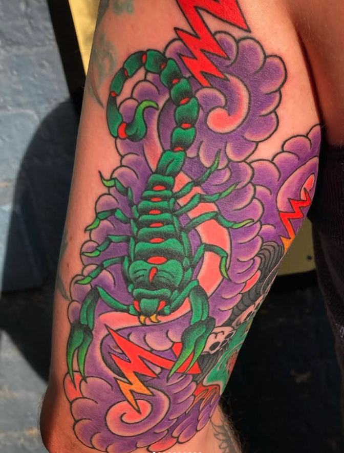 Tattoo of a green and black scorpion with red accents, surrounded by purple clouds and red lightning bolts.