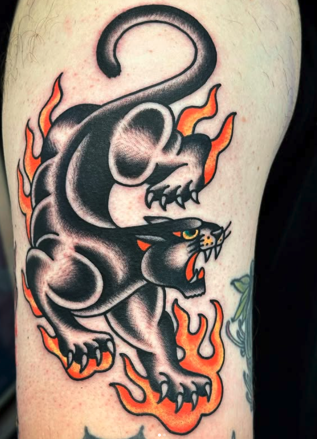 A tattoo of a black panther with flames, part of a larger tattoo on a person's arm.