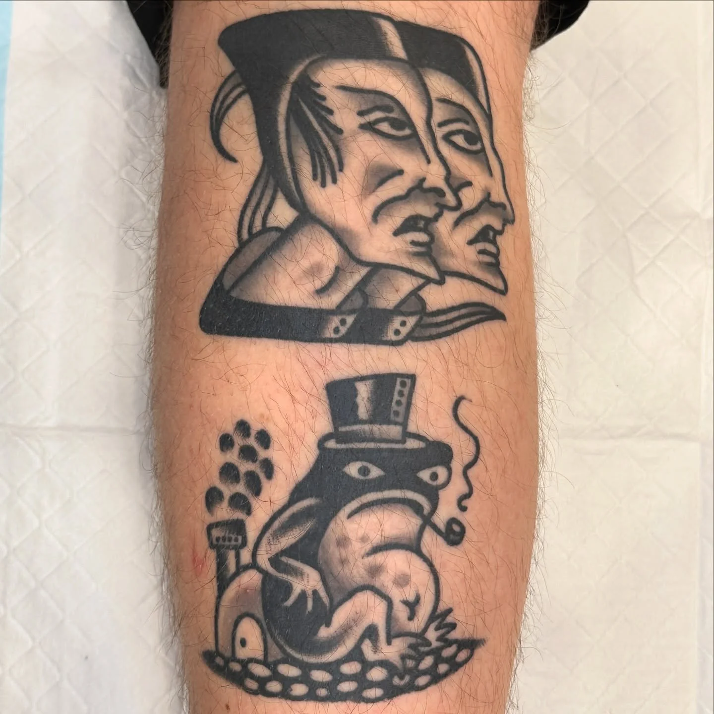Tattoo of three faces above a smoking monkey with a top hat.