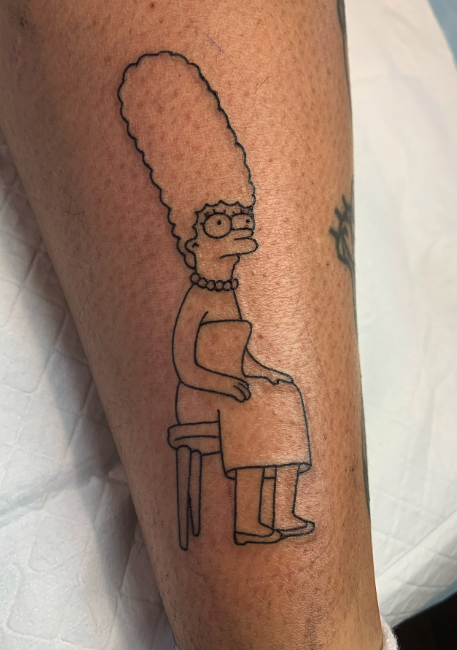 Tattoo of Marge Simpson from The Simpsons, sitting on a stool, in a minimalist black line art style.