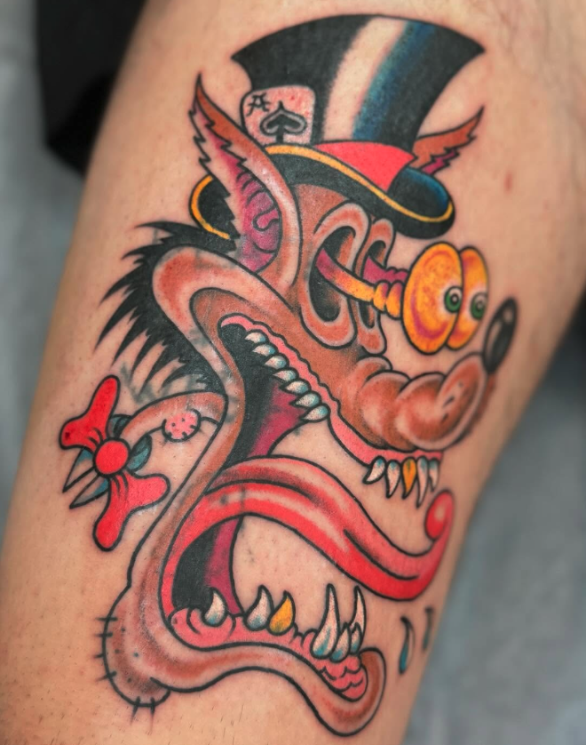 Colorful tattoo of a cartoonish dog with exaggerated features, wearing a top hat and glasses, with a red tongue and a bone in its mouth.