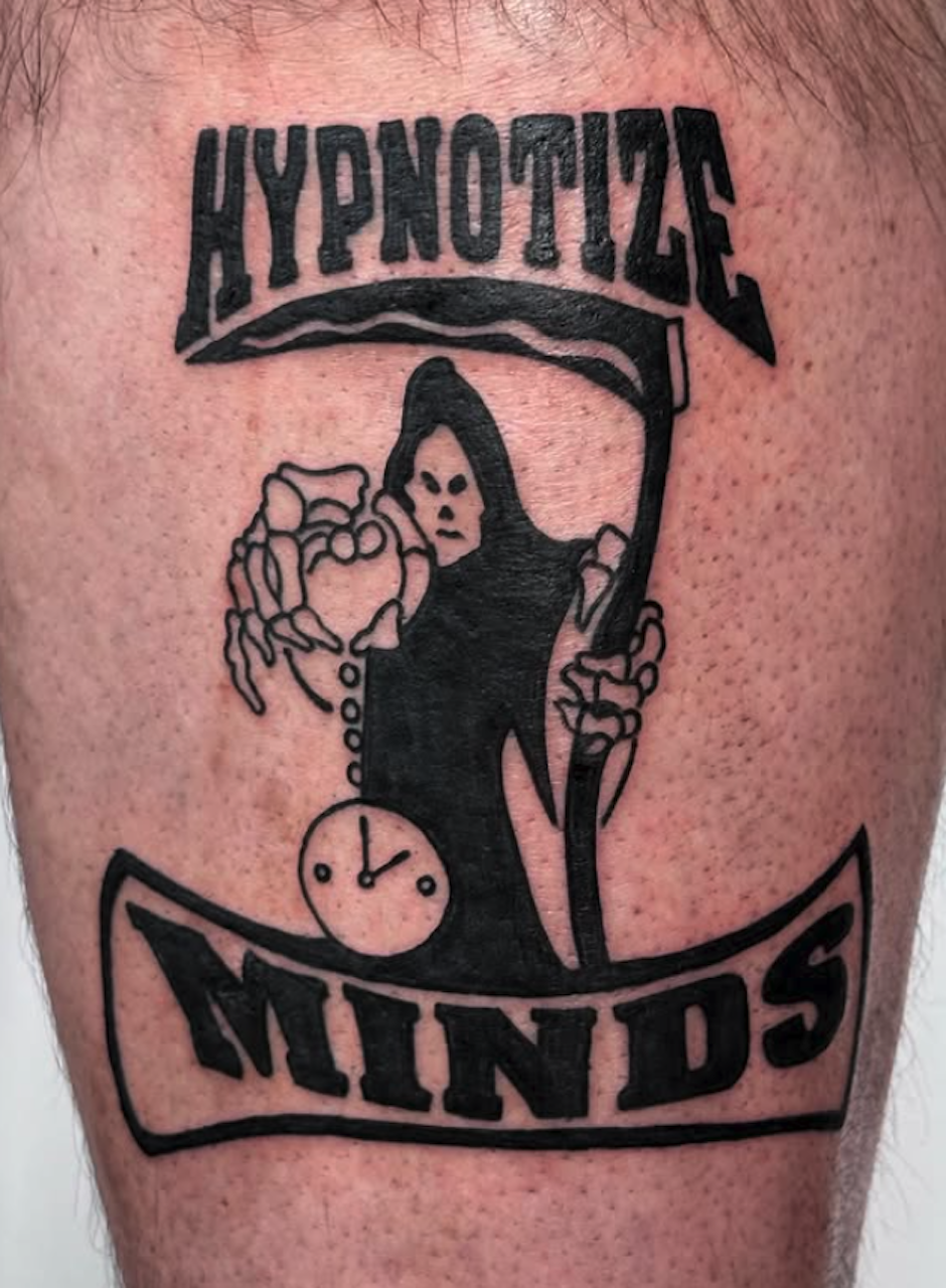 Tattoo of a Grim Reaper holding a scythe, with the text 'Hypnotic Minds' above and below.