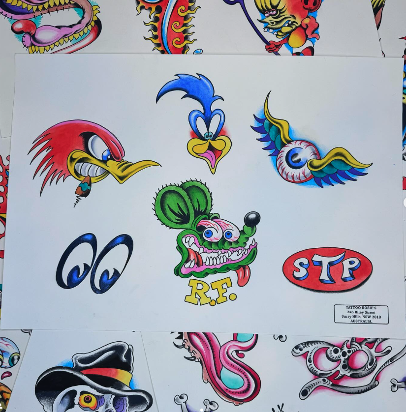 A collection of cartoon-style tattoo designs including a blue bird head, a red and yellow stylized bird, a winged eyeball, black eyes, a green cartoon dog head with tongue out and 'R.E.' beneath it, a red oval with 'STP' in white and blue, and other 