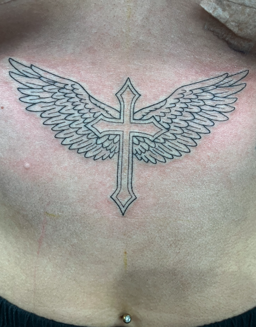 A tattoo of a cross with angel wings on a person's chest.