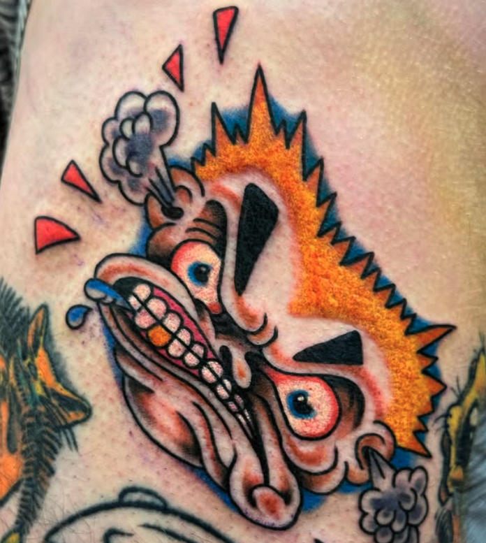 Colorful cartoon-style tattoo of a loud, angry cat with spiky orange fur, screaming with steam coming out of its nose and exaggerated facial features.