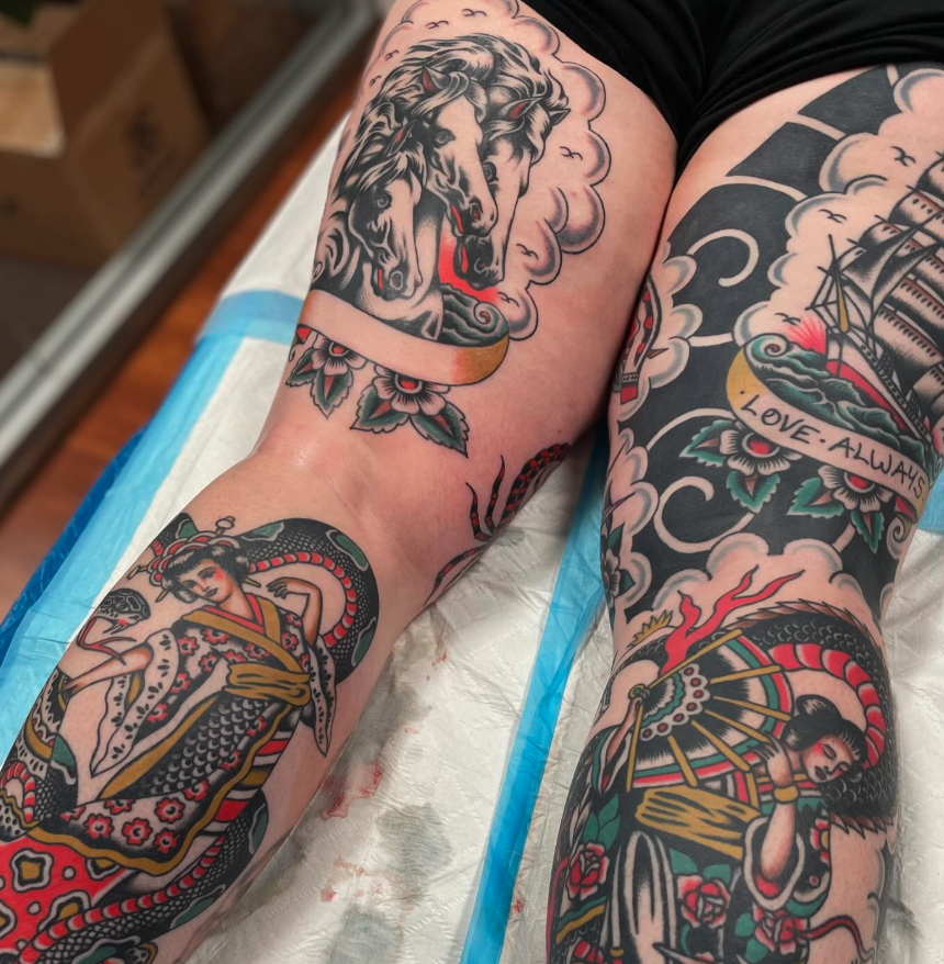 Tattooed legs with traditionally styled tattoos, including a depiction of a woman with a snake, a warrior woman holding a shield, a ship with the words "LOVE: ALWAYS," and a horse's head.