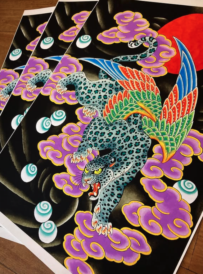 A colorful illustration of a fierce, stylized jaguar with vibrant feathers on its back, surrounded by purple clouds and white orbs, with a red sun in the background.