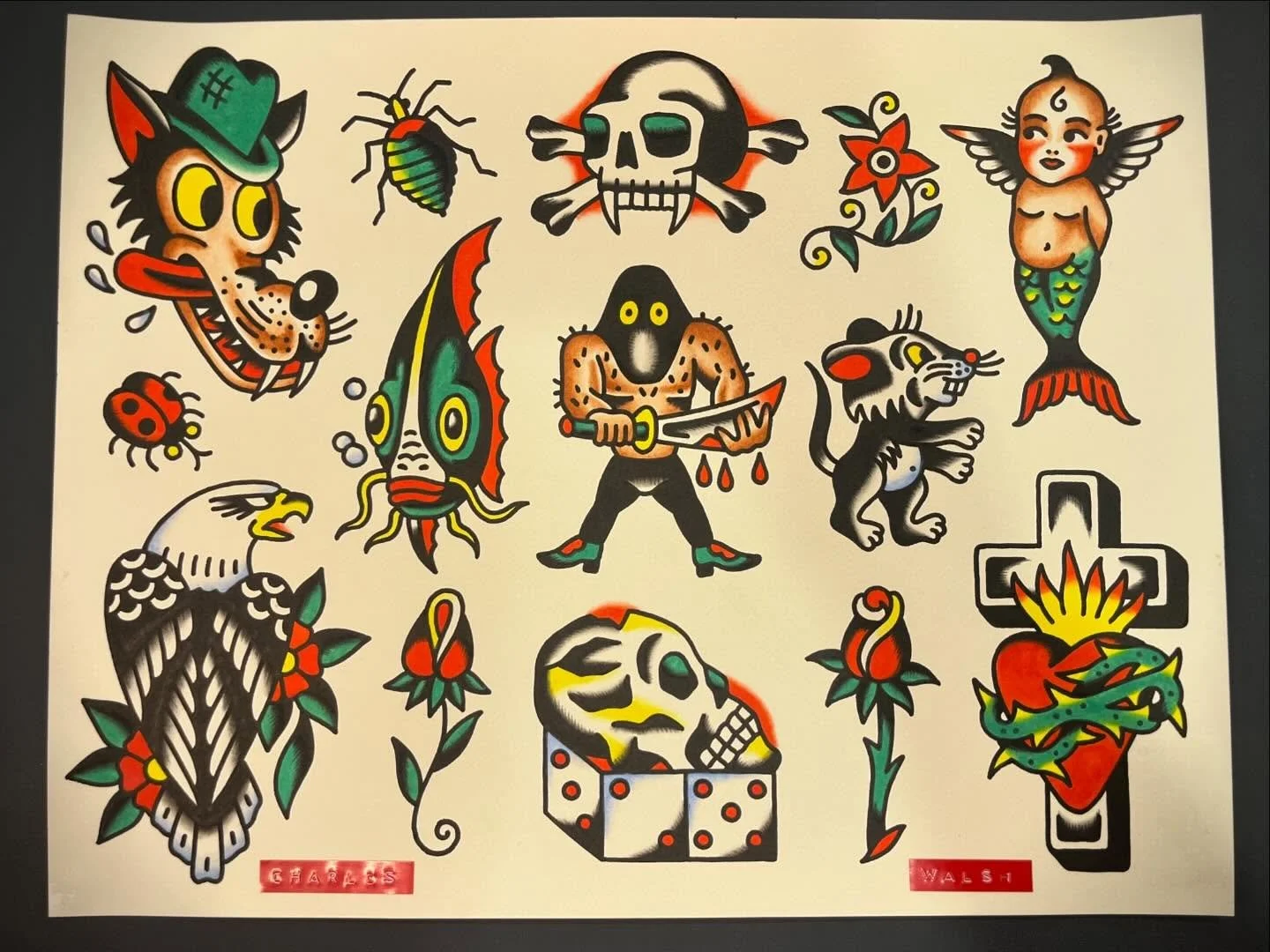 Collection of traditional tattoo-style images including a smiling wolf's head with open mouth, bug, skull with crossed bones, mermaid with wings, eagle head, angry man with a sword, rat, dolphin, heart with a cross and snake, and various flowers and 
