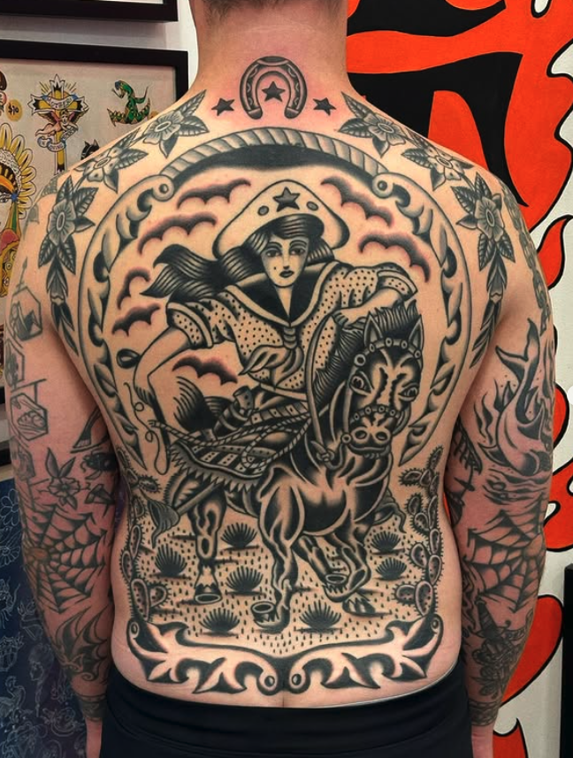 Black and gray tattoo of a woman riding a horse on the chest and abdomen, with floral and decorative elements on the shoulders and arms.