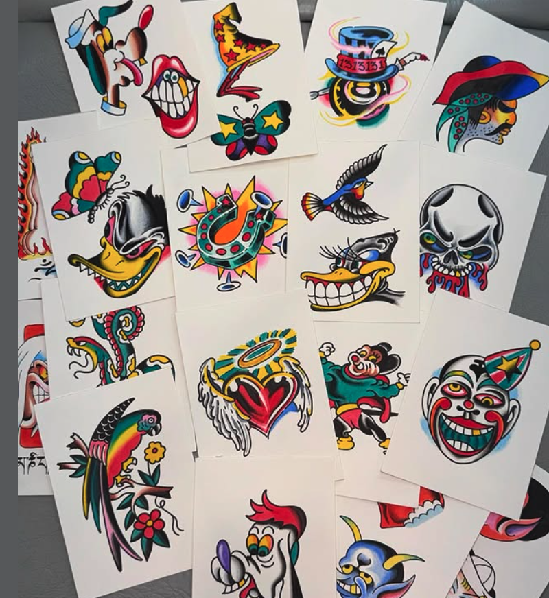 Collection of colorful tattoo flash art featuring various cartoon-style characters including a smiling skeleton, a clown with a cone hat, a butterfly, a bird, a heart with wings, and other whimsical designs