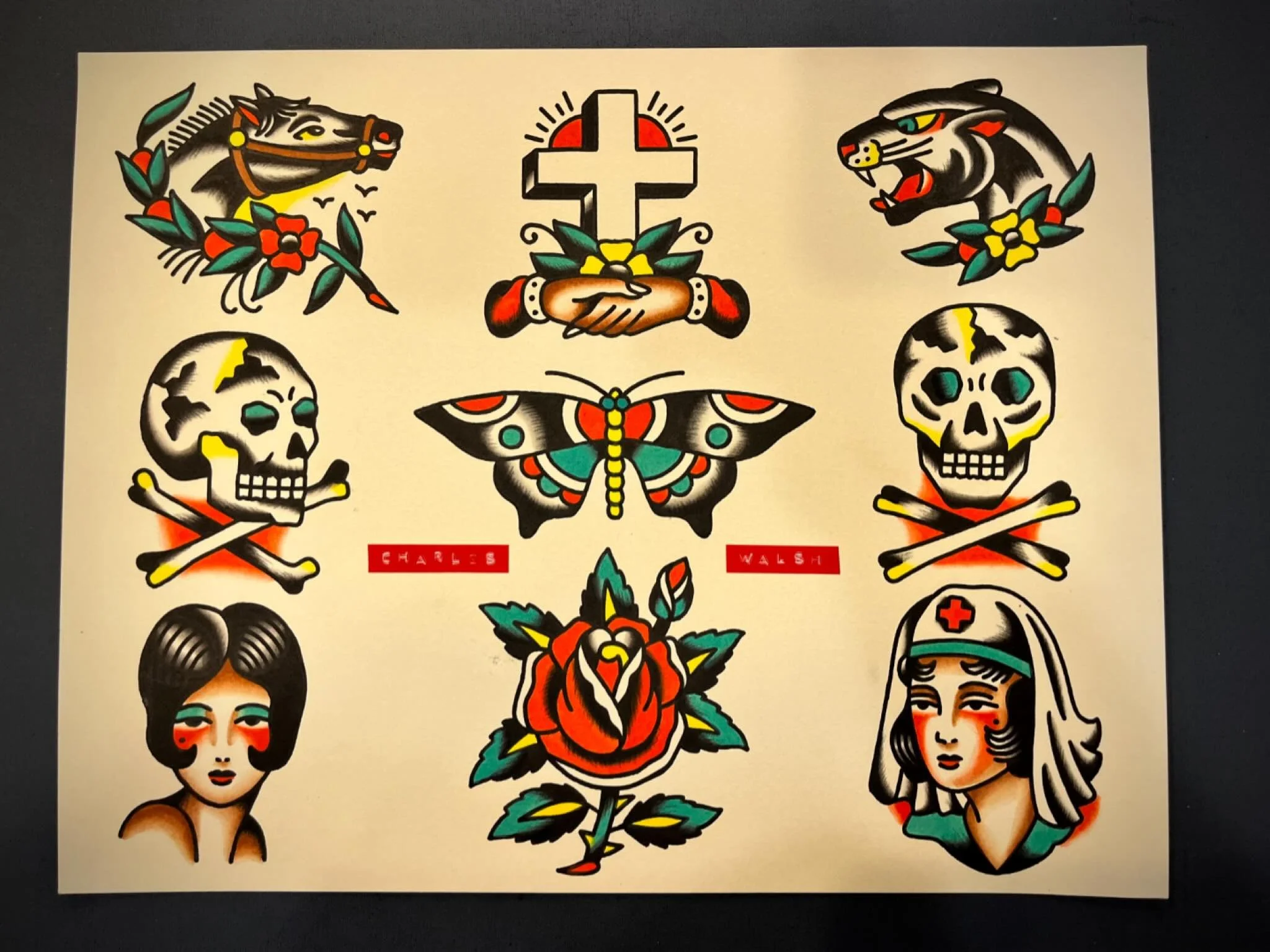 Collection of traditional tattoo-style illustrations including a horse head, a cross with hands holding flowers, a snarling tiger, skulls with crossbones, a butterfly, a red rose, a nurse, and a woman with short dark hair, with the names Charles Wals