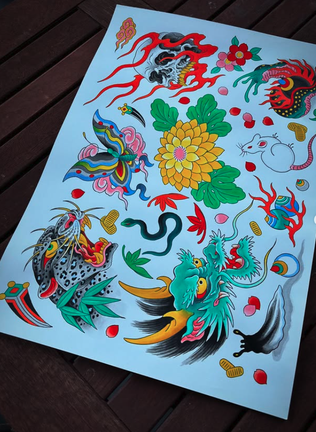 Colorful traditional Japanese tattoo design with dragons, flowers, a lion, and swirling patterns on light blue paper