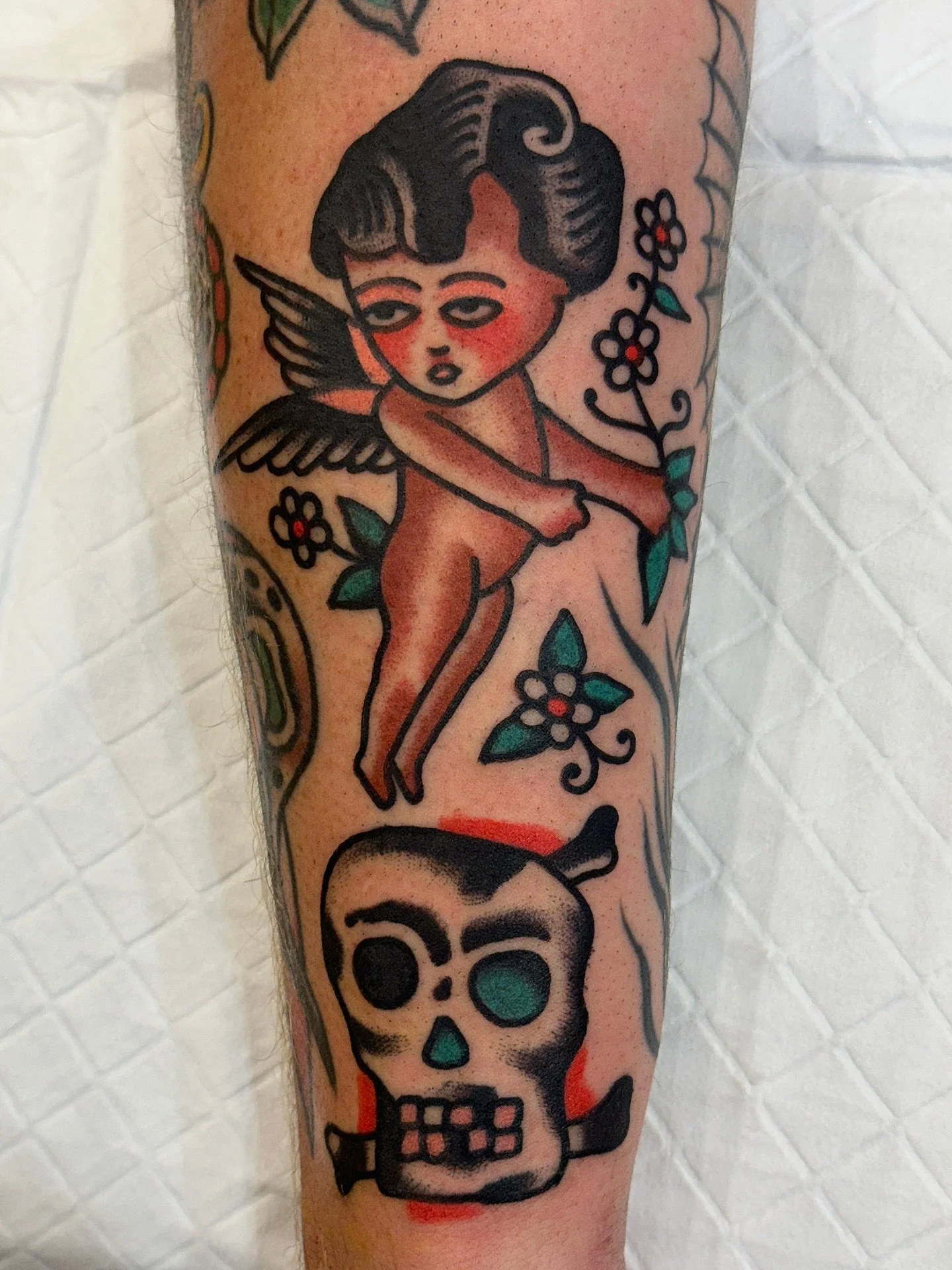 Traditional colour tattoo of a cherub and skull made at Tattoo Rosie's Surry Hills, Sydney