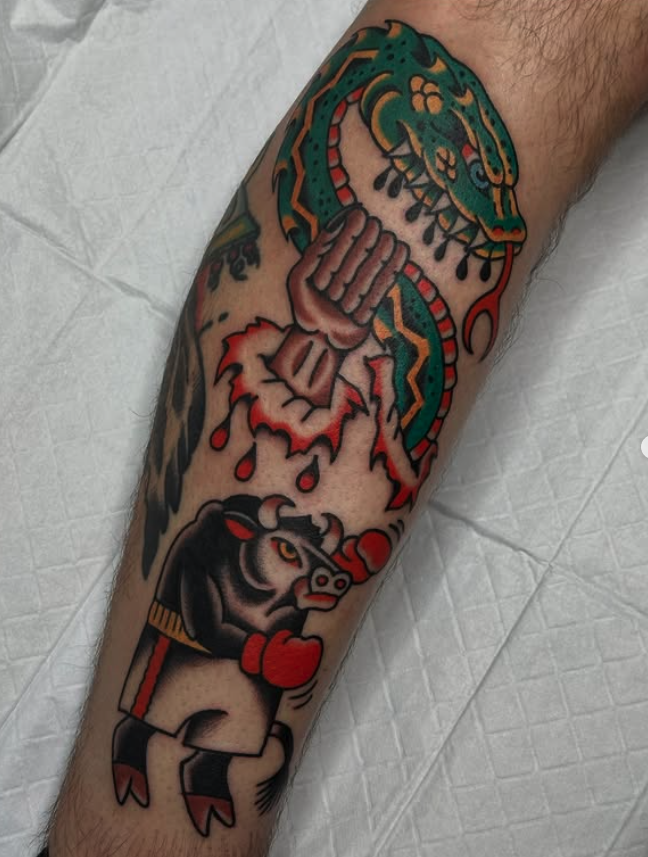 Tattoo of a green and yellow dragon, a clenched fist, and a panther with a boxing glove on its paw on a person's leg.