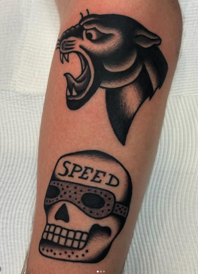Tattoo of a roaring panther head above a skull wearing sunglasses with the word 'SPEED' on the forehead.
