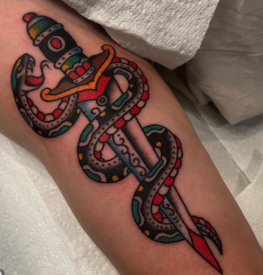 Tattoo of an octopus holding a sword with a sheriff's badge on its head, incorporating bright colors and traditional tattoo style.
