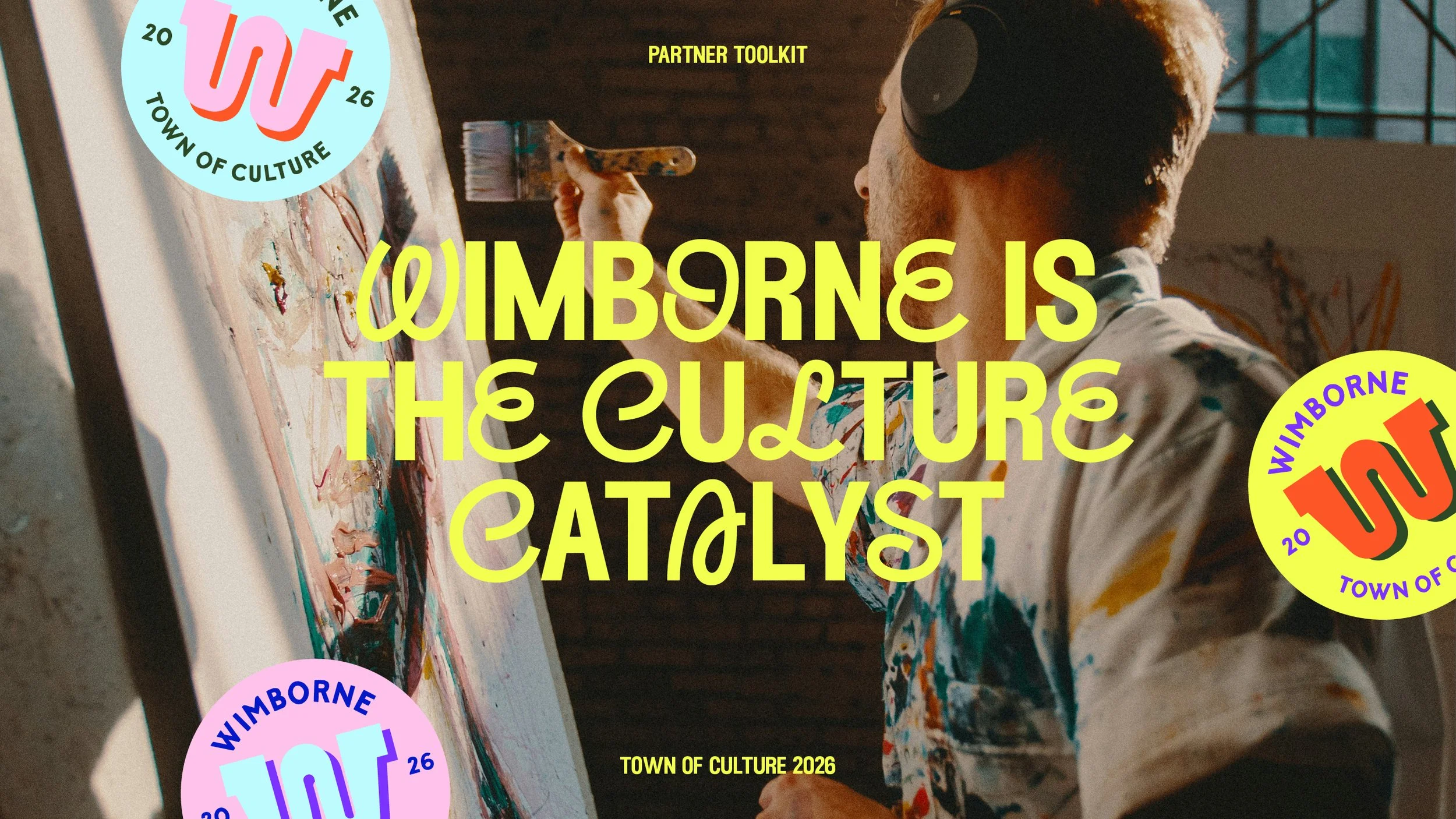 A person wearing a patterned shirt and headphones painting on a canvas in an art studio with large windows. Overlaid text reads: 'Wimbourne is the culture catalyst,' 'Partner toolkit,' and 'Town of Culture 2026,' with colorful circular logos for Wimb
