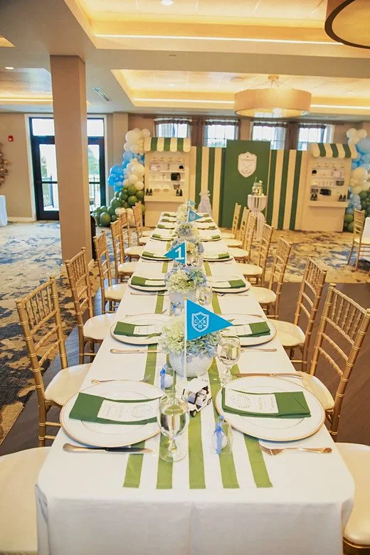 Golf birthday table setting with blue pennant flags, green napkins and a striped runner at Dominion Valley Country Club in Haymarket, VA