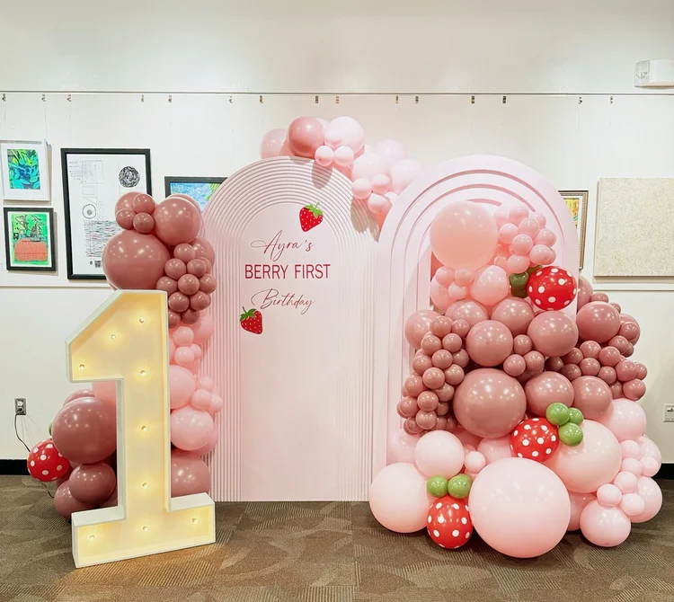 Strawberry themed first birthday with pink arch backdrops, a light-up marquee number 1 and pink, mauve and strawberry balloon garlands in Reston, Virginia