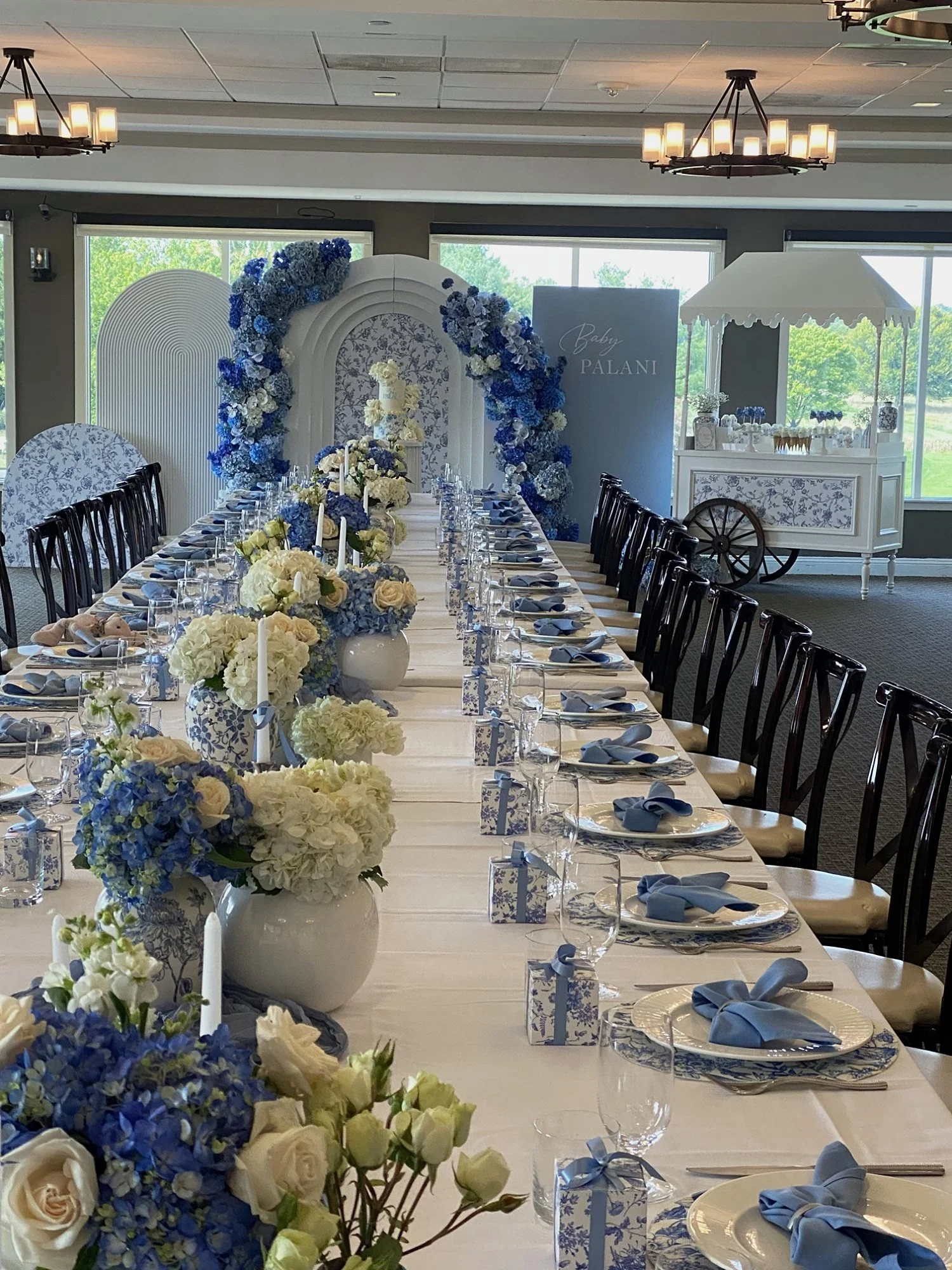 Blue and white chinoiserie baby shower with a hydrangea floral arch, arched backdrops, ginger jar centerpieces and a candy cart at Chantilly National Golf & Country Club in Centreville, Virginia