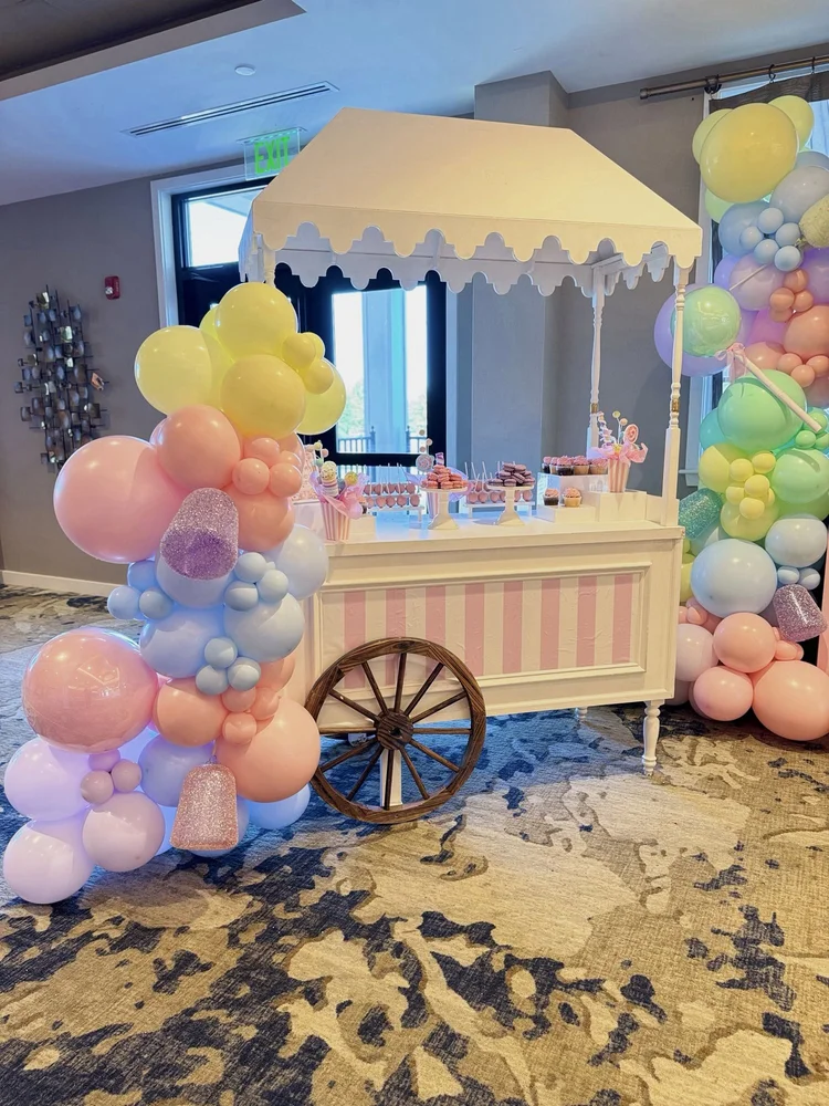 White candy cart rental with pink stripes and pastel balloon garlands at Dominion Valley Country Club in Prince William County