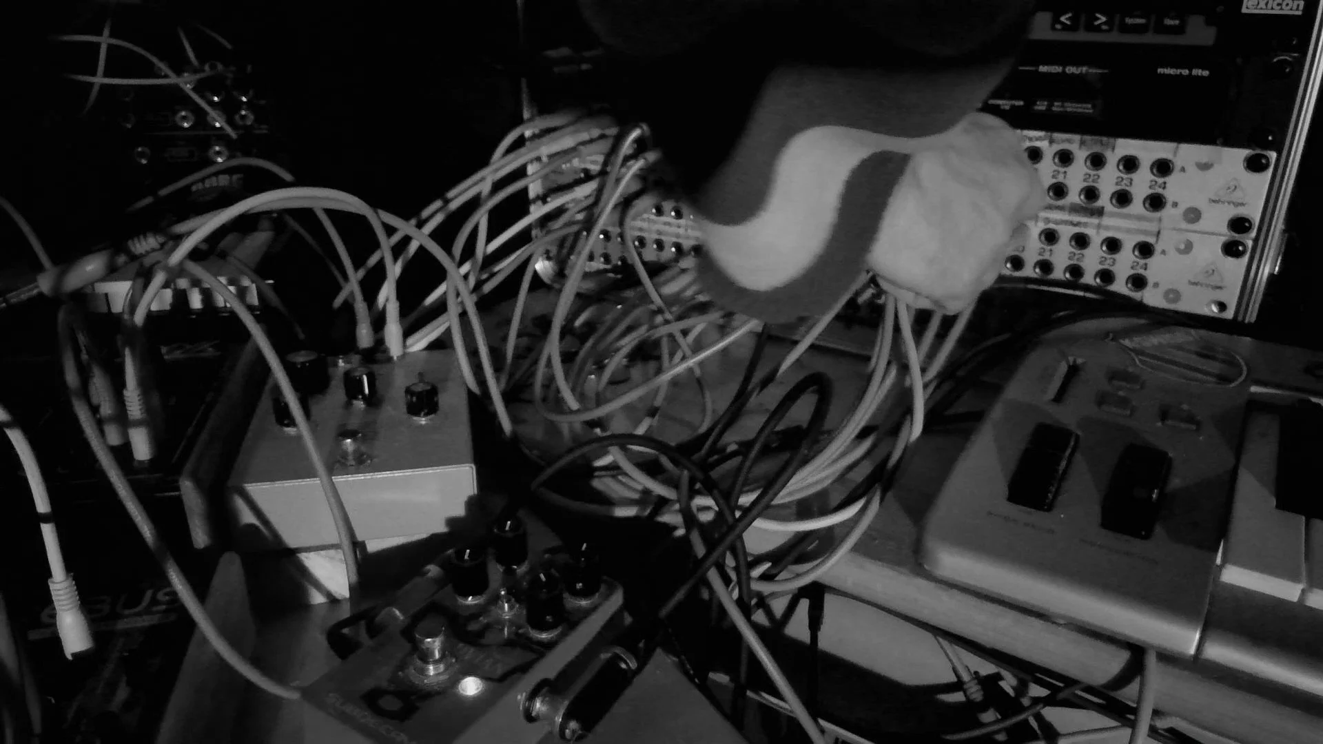 Close-up of electronic audio equipment with many wires, knobs, and patch bays, possibly a sound mixing or synthesizer setup.