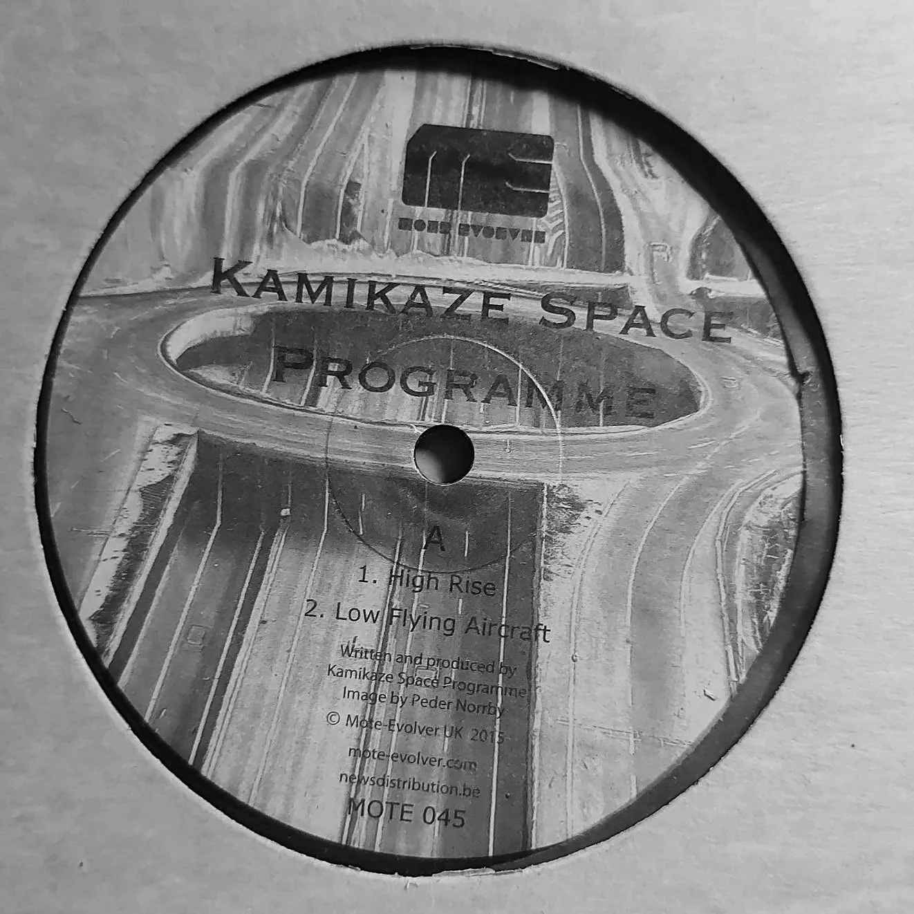 A CD titled 'Kamikaze Space Programme' with a cover image featuring a space-themed design, depicting a runway and spacecraft, and includes track list: '1. High Rise' and '2. Low Flying Aircraft'.