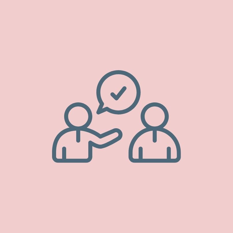 Line drawing of two people having a conversation, with one person raising an arm, and a speech bubble with a check mark between them, on a pink background.