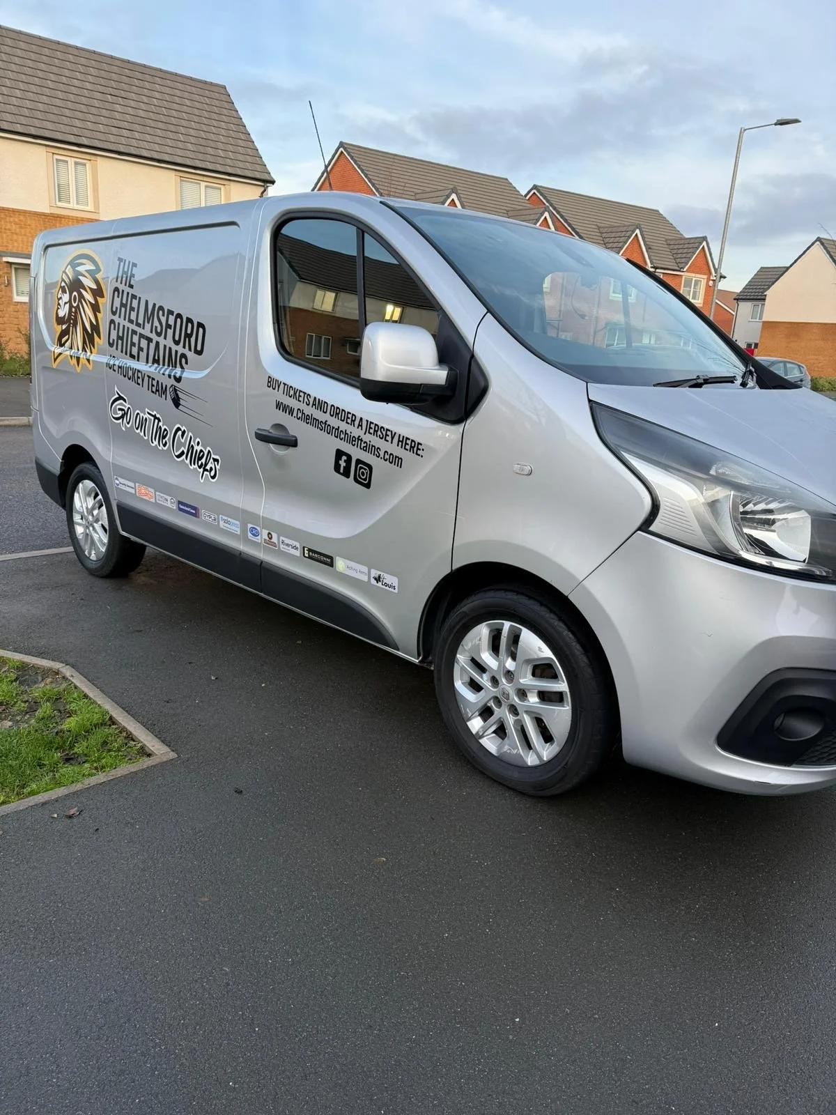 Silver van parked on the street with logo and advertisements for Chelmsford Chiefs ice hockey team.