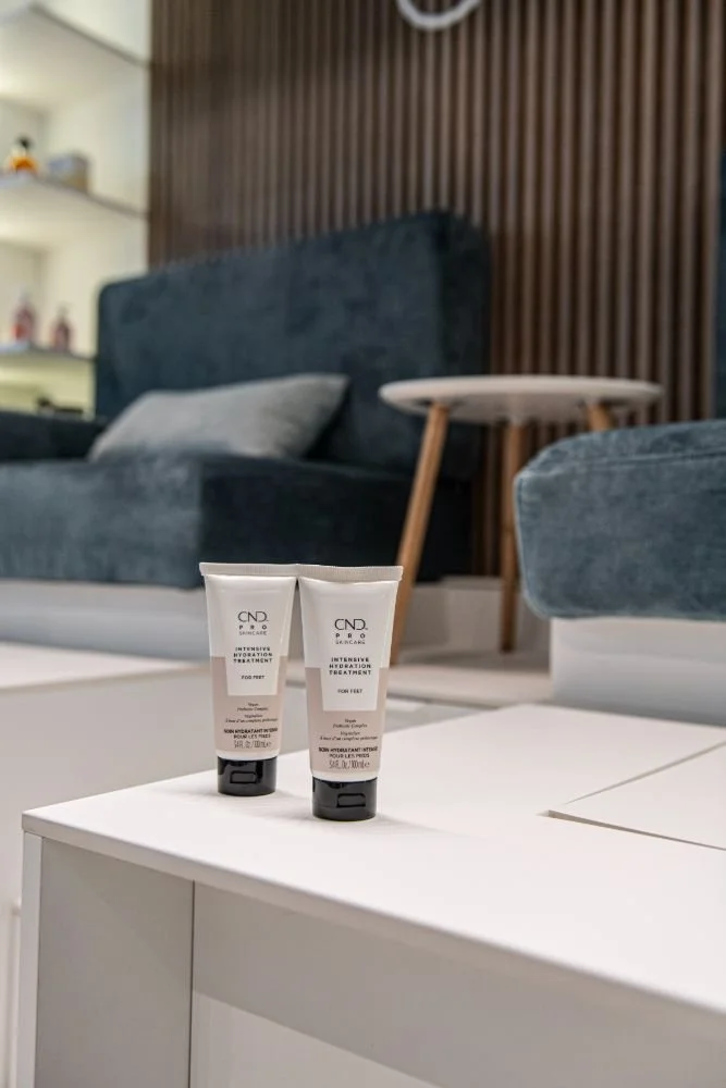 Two tubes of CND Intensive Hydration Treatment placed on a white table in a modern living room.